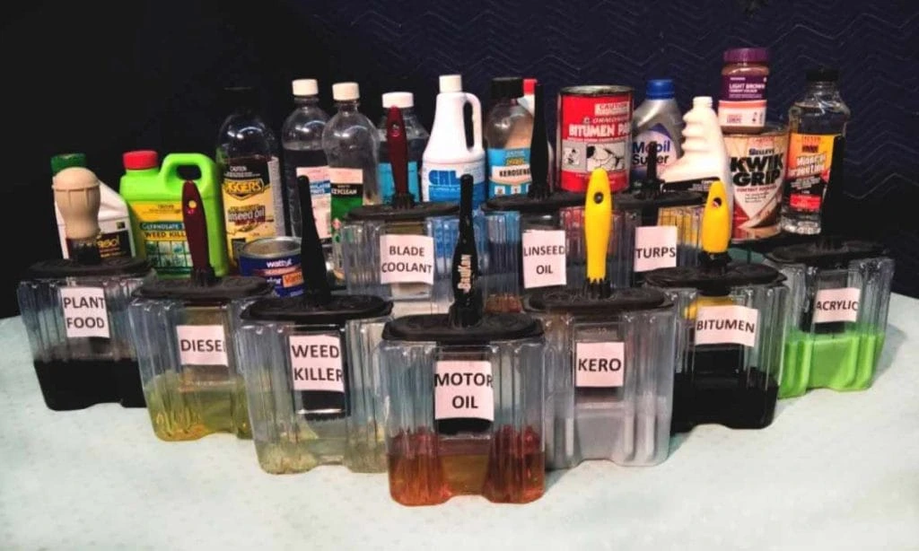 A group of bottles with different products and a group of BruKon brush containers with different liquids and brushes inside